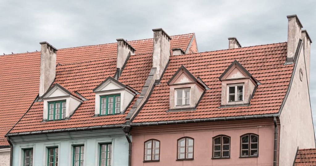 Maison avec toiture rouge et fenêtre en chien assis