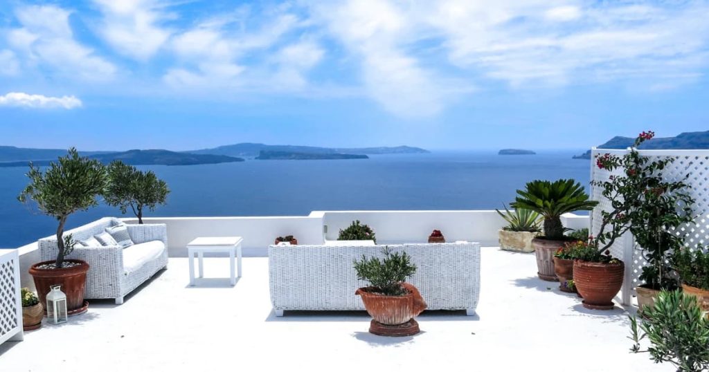 Toit terrasse blanc avec meubles en blanc et vue sur la mer. 