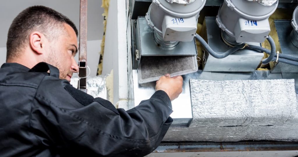 Technicien qui vérifie le filtre du système de ventilation