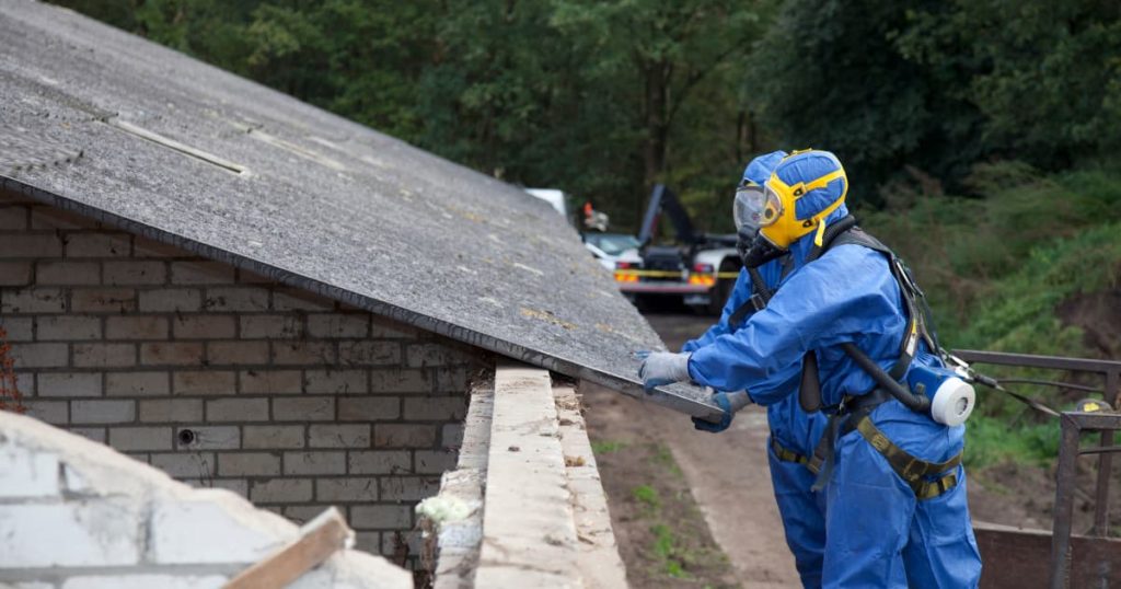 Élimination d'une plaque en amiante par un professionnel en équipement de sécurité