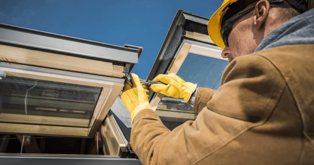 Un couvreur installant une fenêtre de toit velux