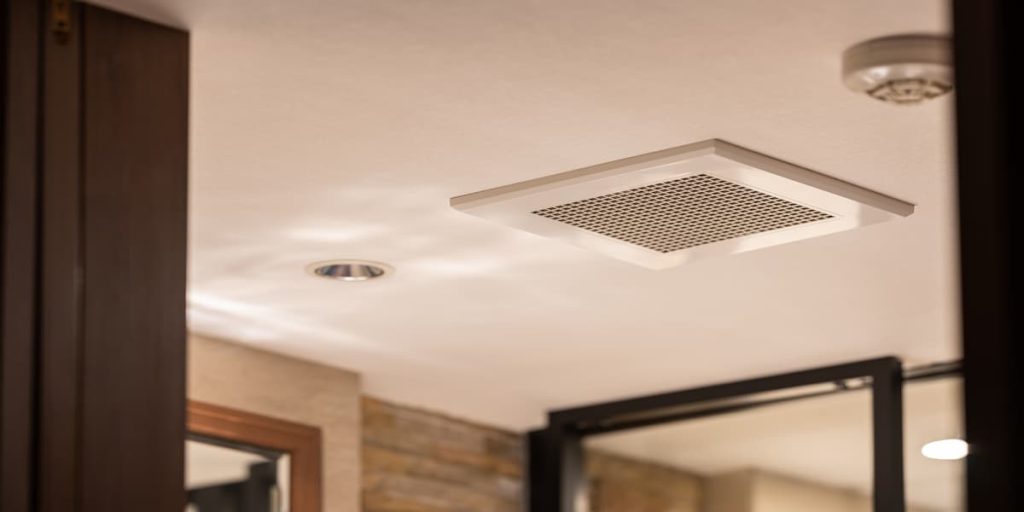 Grille de ventilation dans le plafond d'une salle de bain