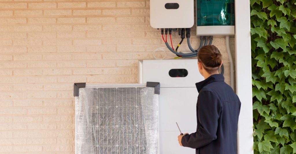 Homme avec un tournevis qui observe une batterie pour panneaux solaires 