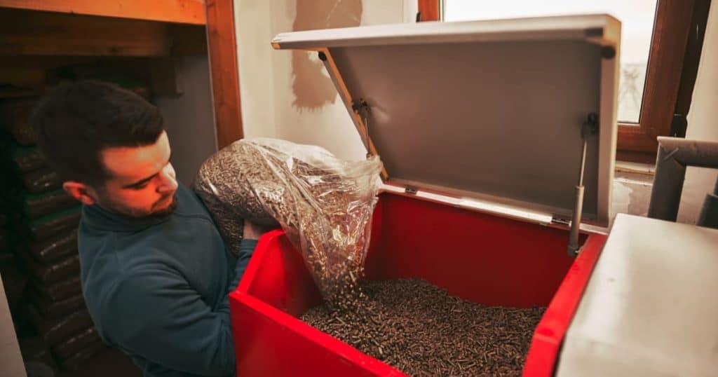 Homme utilisant des granulés en bois pour la chaudière à condensation