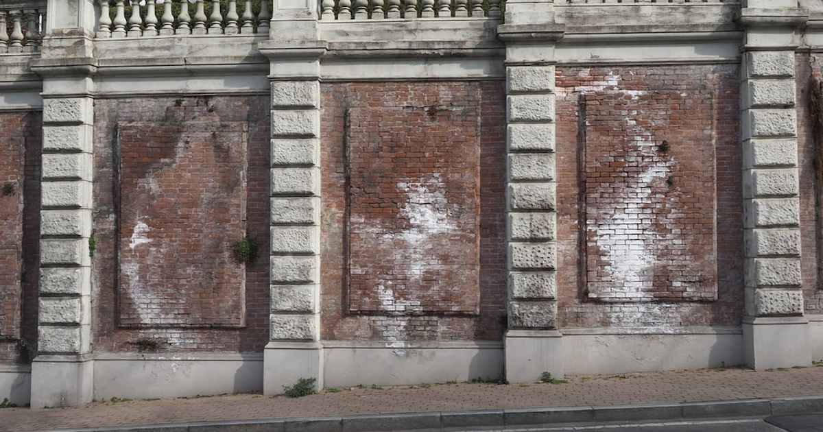 Tâches d'efflorescences blanchâtres sur un mur extérieur.