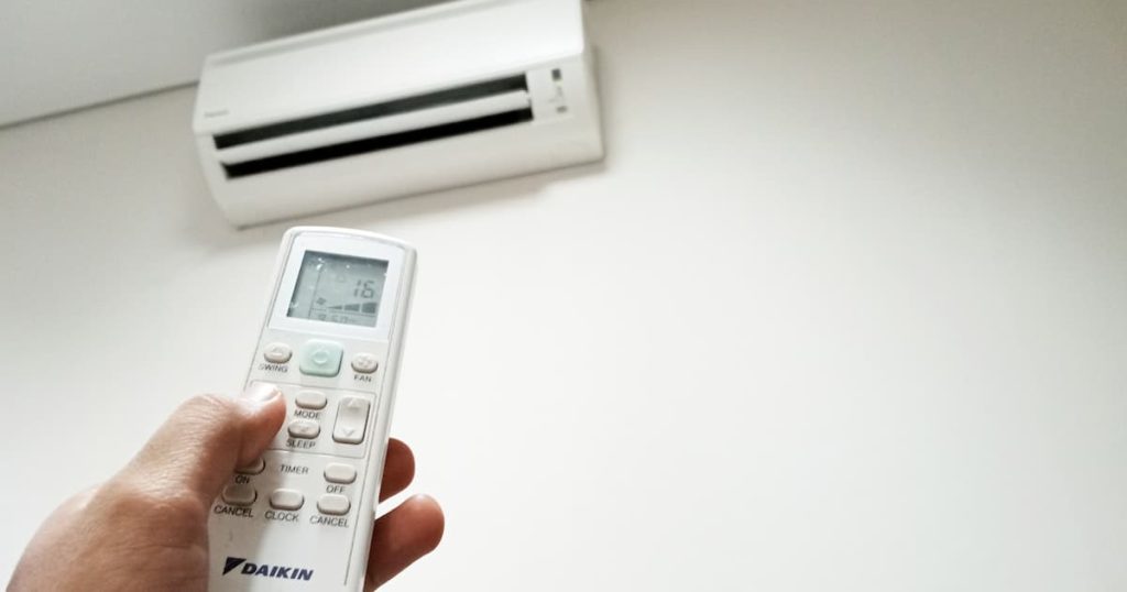 Une télécommande de climatiseur Daikin pointant vers l'unité intérieure