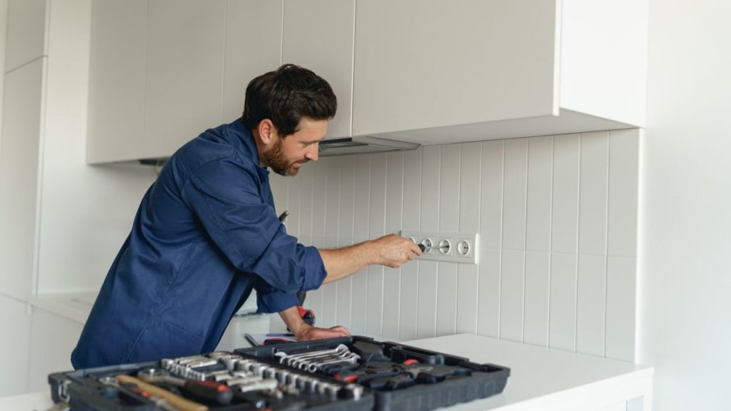 Professional installeert stopcontacten volgens voorschriften in keuken