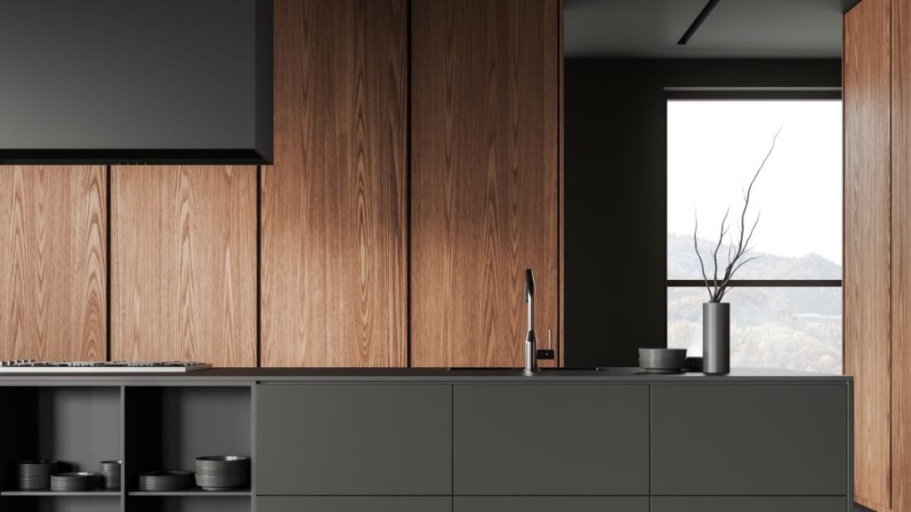 Moderne, minimalistische antraciet keuken met houten elementen. De wandkasten hebben deurtjes in donker hout. Het keukeneiland en werkblad zijn van kunststof; Het servies is in dezelfde kleur als het keukeneiland, antraciet.