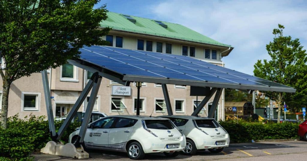 Zonnepanelen op een carport voorzien de bedrijfswagens van stroom voor het opladen.