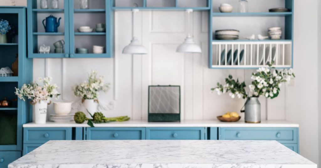 Witte en blauwe keuken met verschillende wandplanken als opbergruimte 