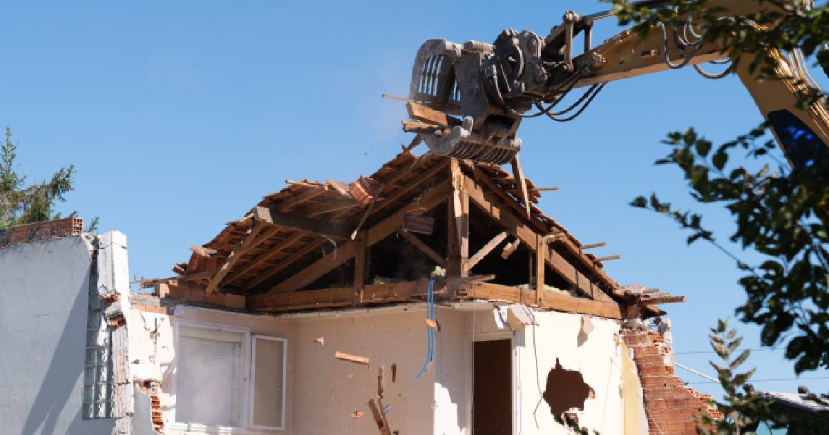 Een woning wordt gesloopt met een kraanwagen. De eigenaar kan beroep doen op de sloop- en heropbouwpremie als hij niet in aanmerking komt voor het verlaagd btw-tarief voor sloop- en heropbouwwerken.