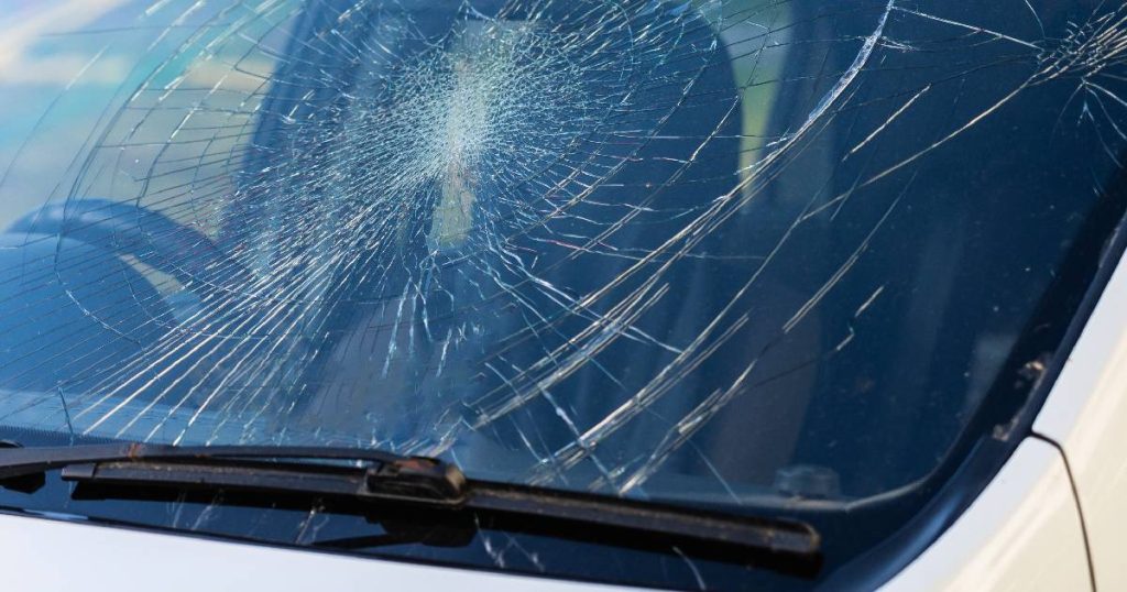 Een witte auto met een gebroken voorruit. Een geval van glasbreuk, een van de schadegevallen waartegen je jezelf, voor een prijs, financieel kunt beschermen met een kleine omnium autoverzekering.