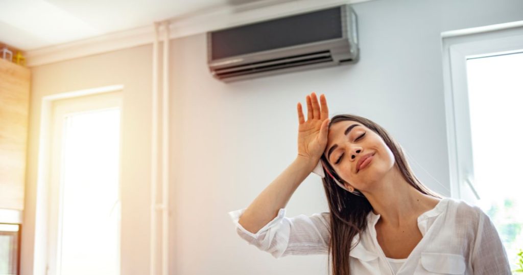 Een vrouw die haar hand op haar voorhoofd zet vanwege de hitte