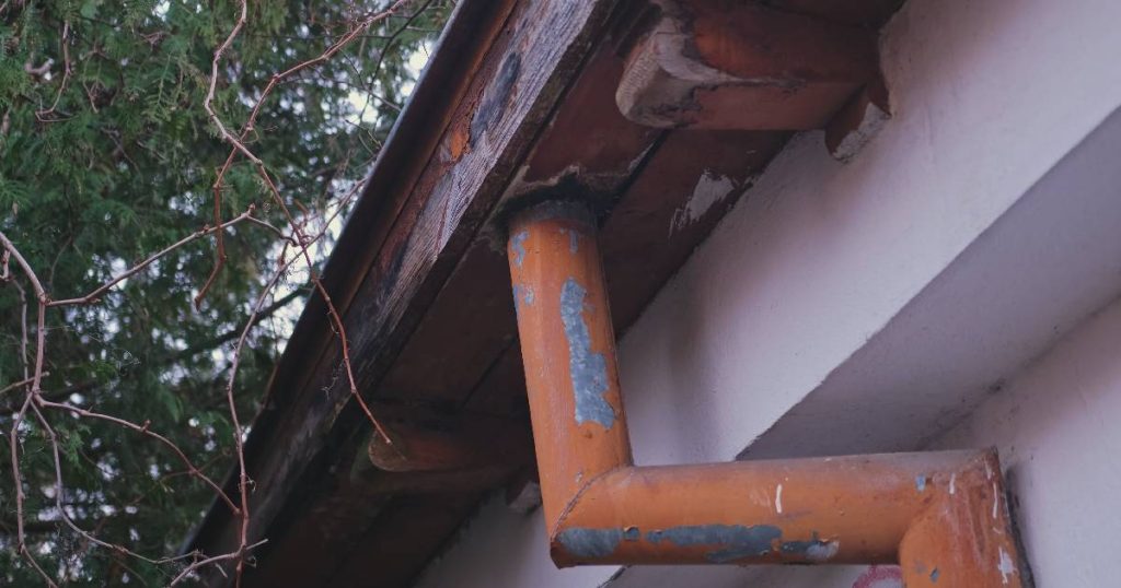 Een oude dakgoot met roest en houten buitenbekleding die men niet langer kan herstellen: vervangen is hier de enige duurzame optie.