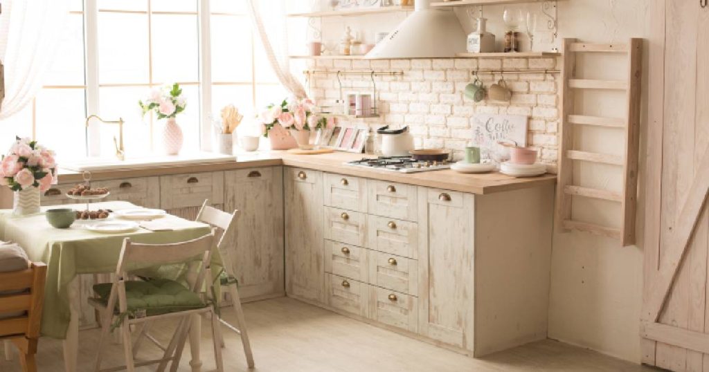 Een kleine houten keuken in gezellige landelijke stijl met leuke decoratiestukken zoals een ladder, pastelkleurige vaasjes en zwevende planken.