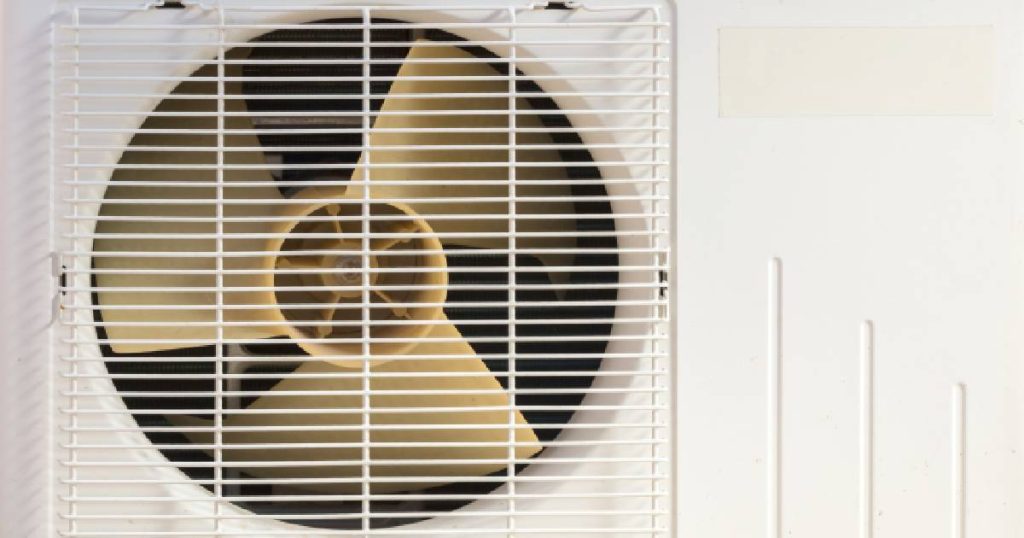 Detail van een witte ventilator en het witte rooster van een airco die meerdere kamers kan koelen. 