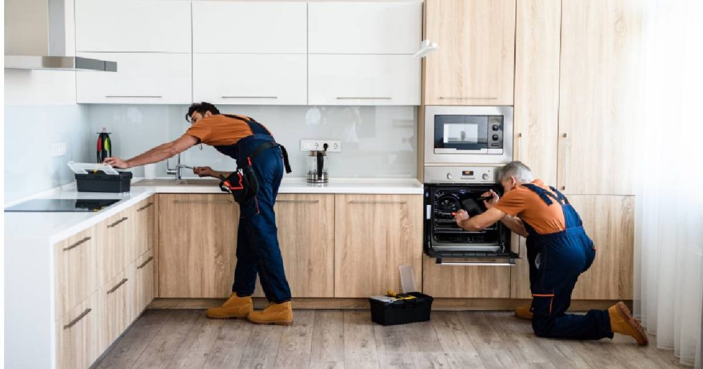 Twee keukenspecialisten monteren een nieuwe eenvoudige keuken.