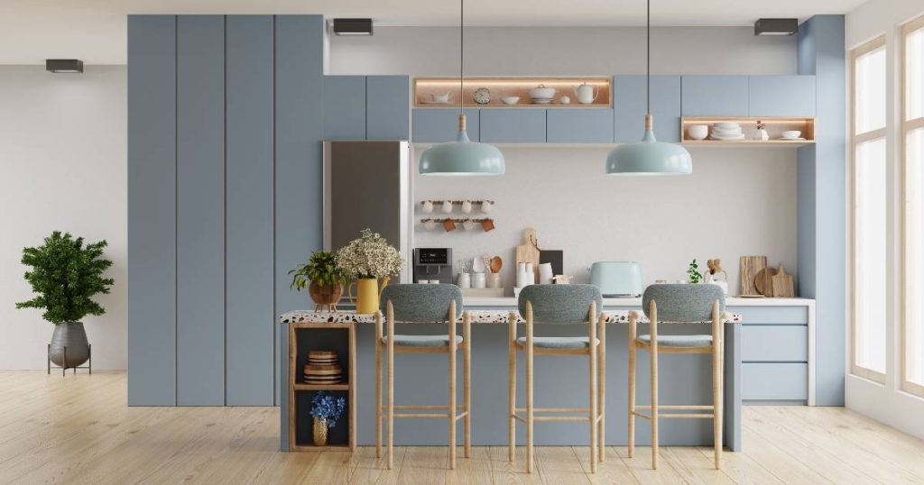 Hier werd de vraag 'in welke kleur moet ik de keuken verven' volmondig beantwoord met 'blauw en wit'! Deze moderne, greeploze keuken met blauwe keukenkasten, een blauw keukeneiland en houten stoelen met blauwe zittingen oogt zacht en gezellig. De houten vloer en het vele daglicht dat binnenkomt door de grote ramen zorgen, samen met de vele kamerplanten, voor een natuurlijke look.