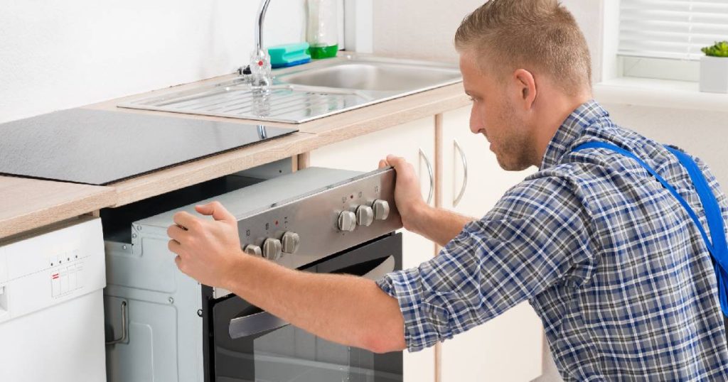 Een keukenspecialist in de weer met het plaatsen van een oven in een nieuwe keuken. Omdat de klant koos voor een kant-en-klare keuken, ligt de levertijd wat lager.