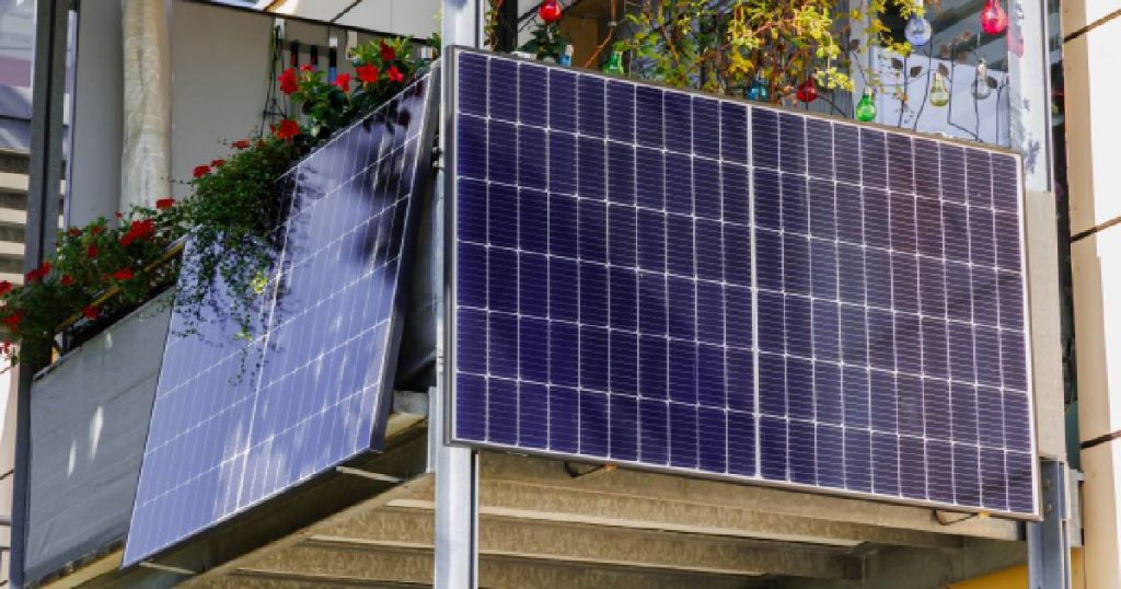 Twee grote plug and play zonnepanelen die aan een balkon bevestigd zijn.