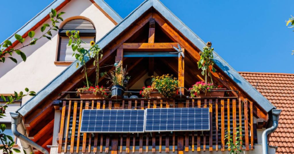 Een gevel en het dak van een woning. Aan de gevel is een set met twee kleine plug and play zonnepanelen bevestigd.